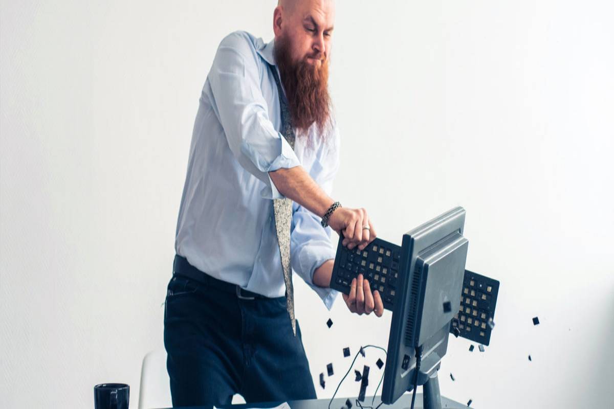 Man smashing keyboard on computer screen