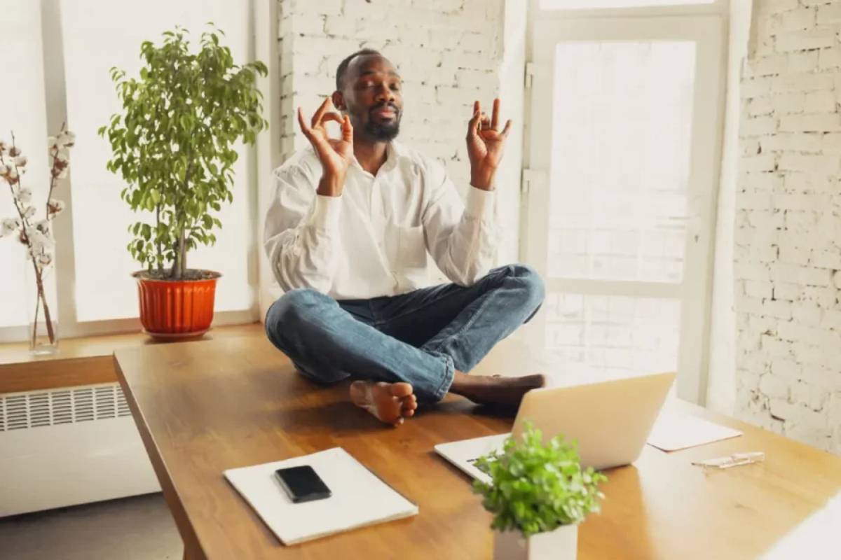 Man meditating on office desk