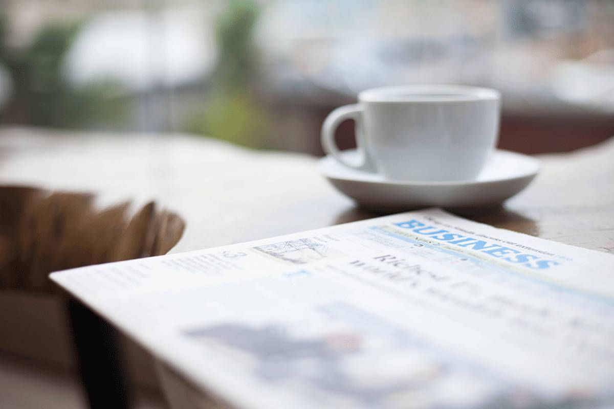 Tidning och kaffekopp på ett bord