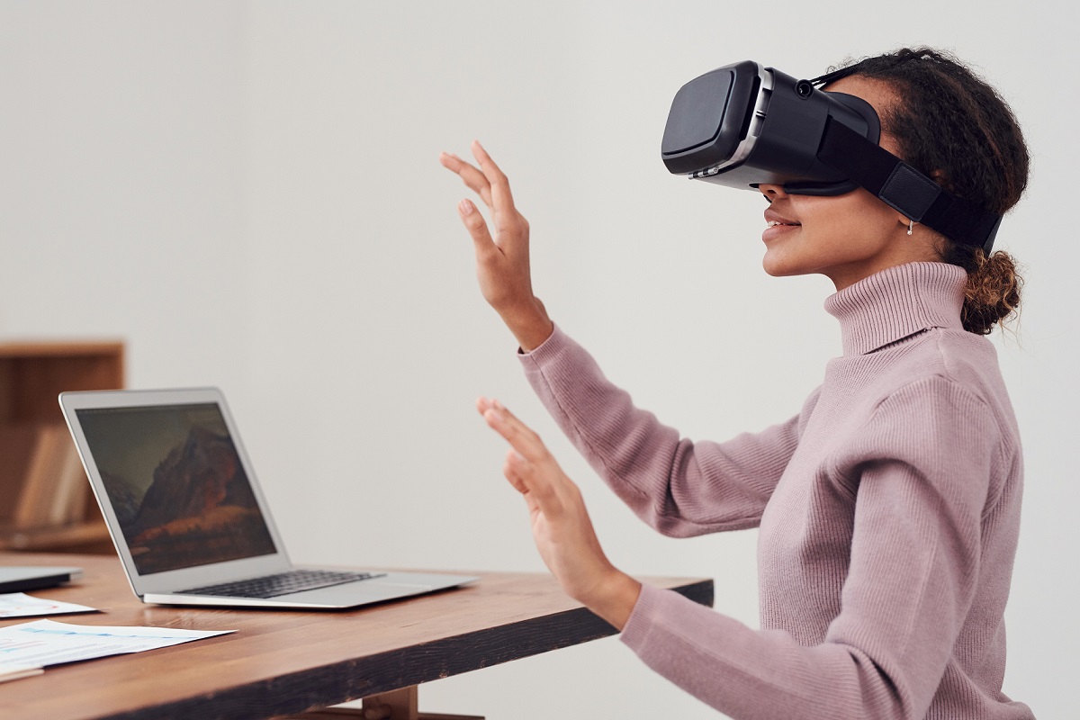 Woman with VR headset on and an laptop in front of her