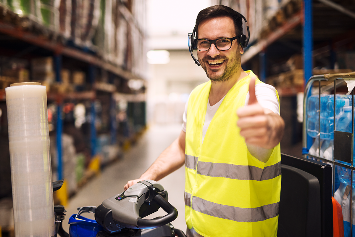 Warehouse worker with headset communication organizing goods delivery