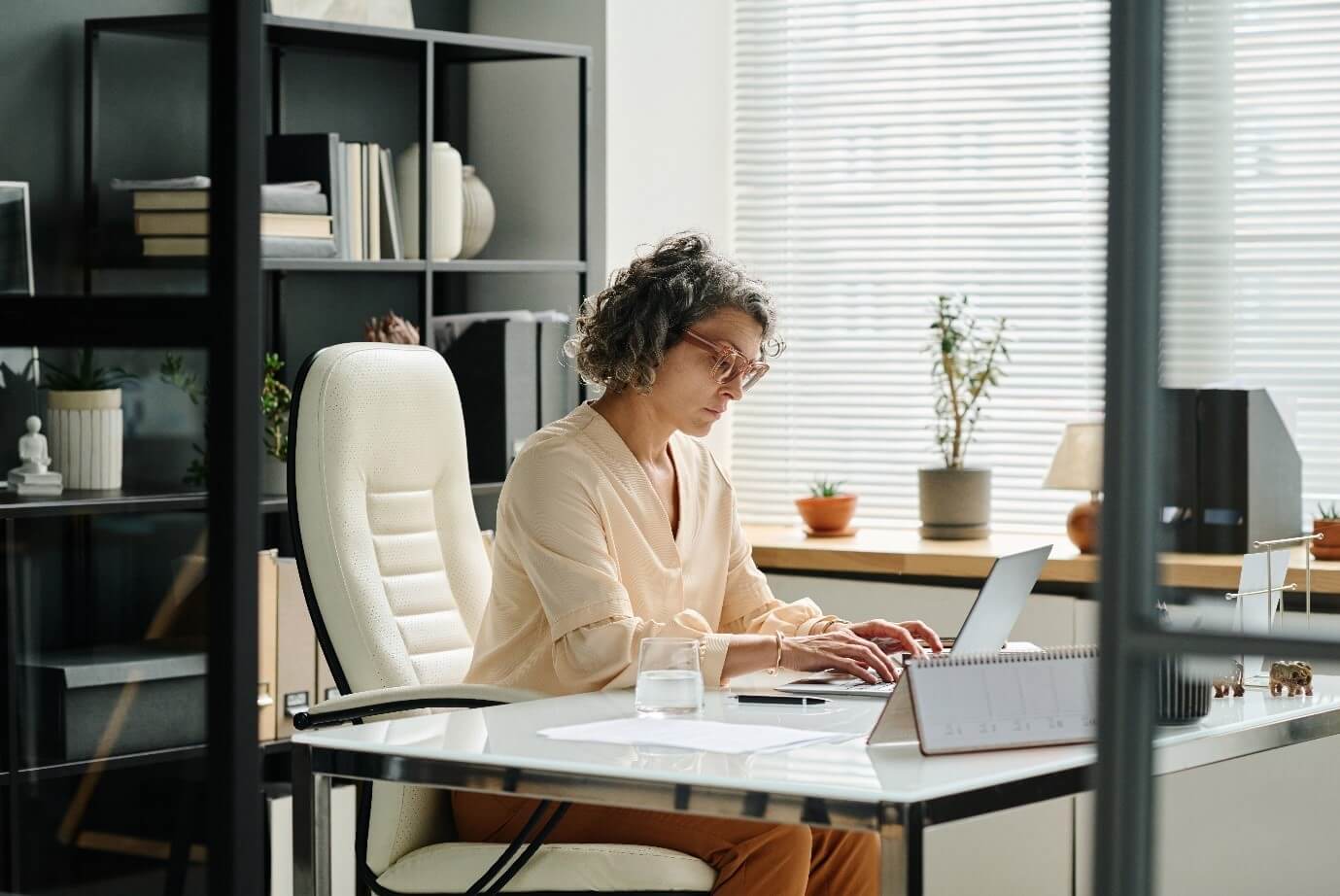 Woman at desk typing on laptop