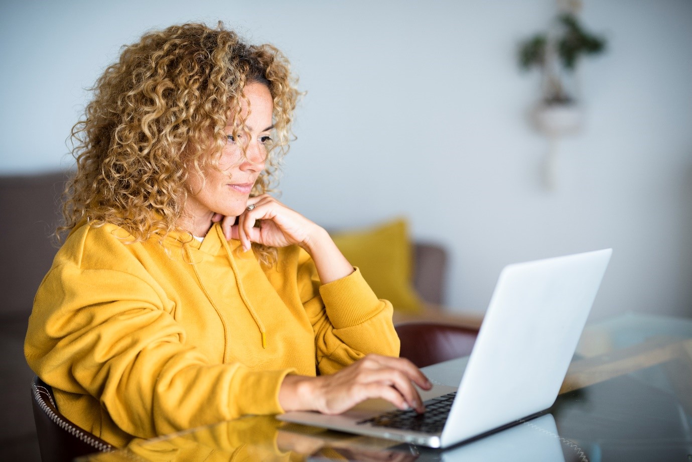 Female in yellow blouse on laptop