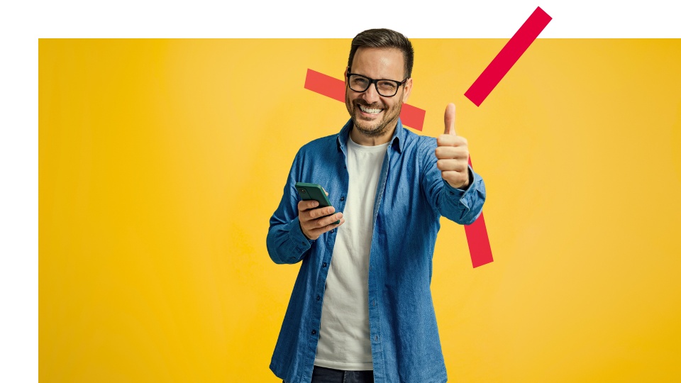 Man with glasses holding a mobile phone and showing a thumbs up on yellow background with sparks.